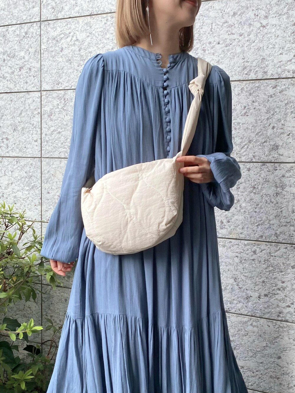 ホワイト系のショルダーバッグ、ブルー系のワンピース、ホワイト系のスニーカーを着用したレディースの春コーディネートの5枚目の写真