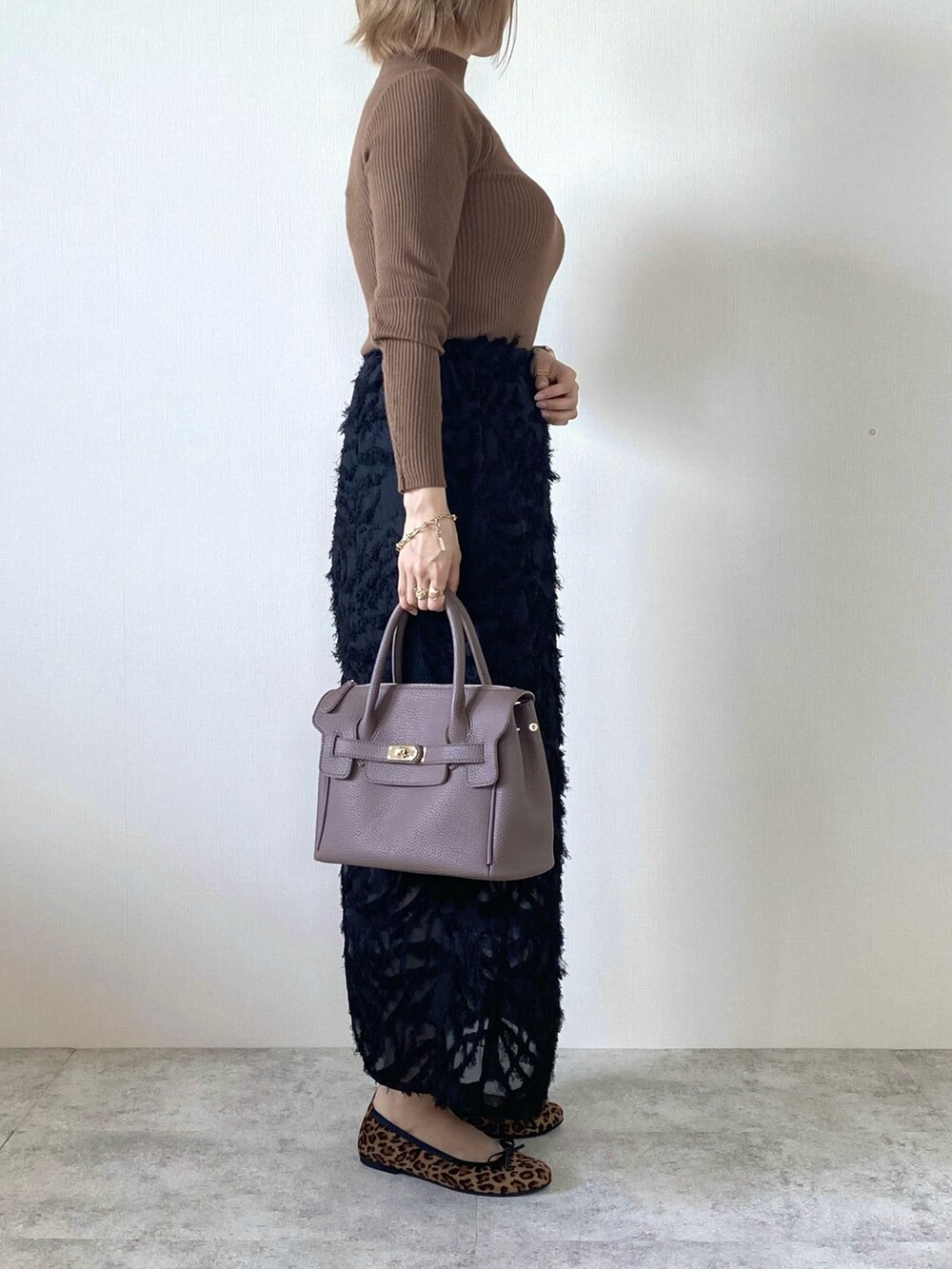 ブラック系のスカート、ブラウン系のバレエシューズ、ブラウン系のニット/セーターを着用したレディースの秋コーディネートの2枚目の写真