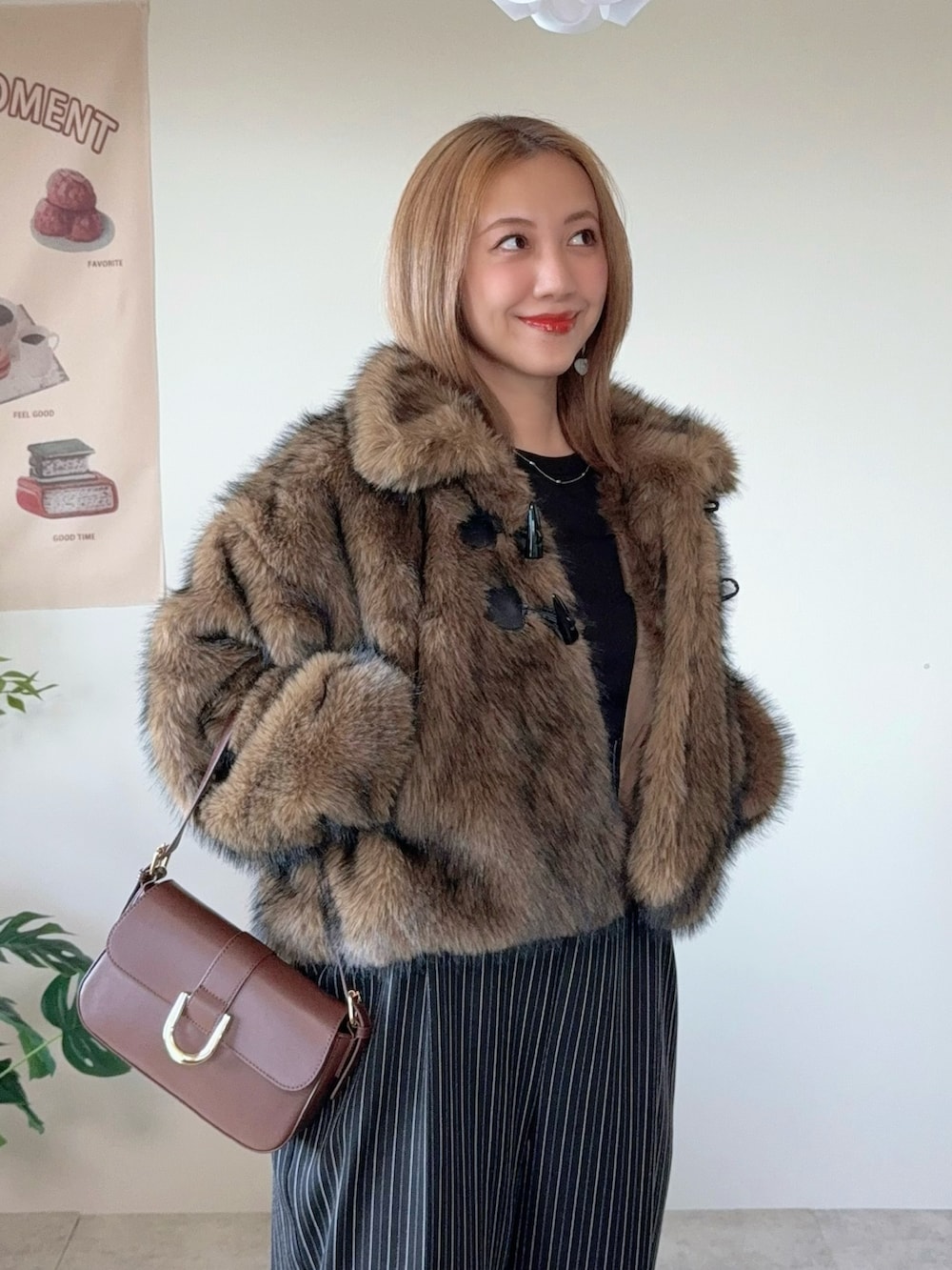 ブラウン系のブルゾン、ブラウン系のハンドバッグ、ブラック系のその他パンツを着用したレディースの冬コーディネートの2枚目の写真