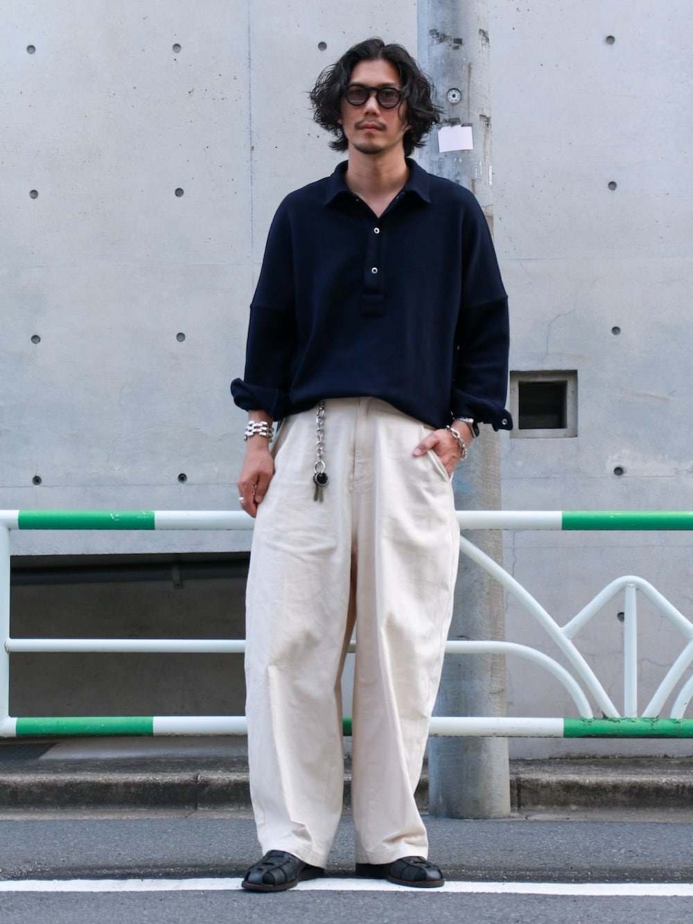 ブルー系のポロシャツ、ホワイト系のデニムパンツ、ブラック系のサンダルを着用したメンズの春コーディネートの2枚目の写真