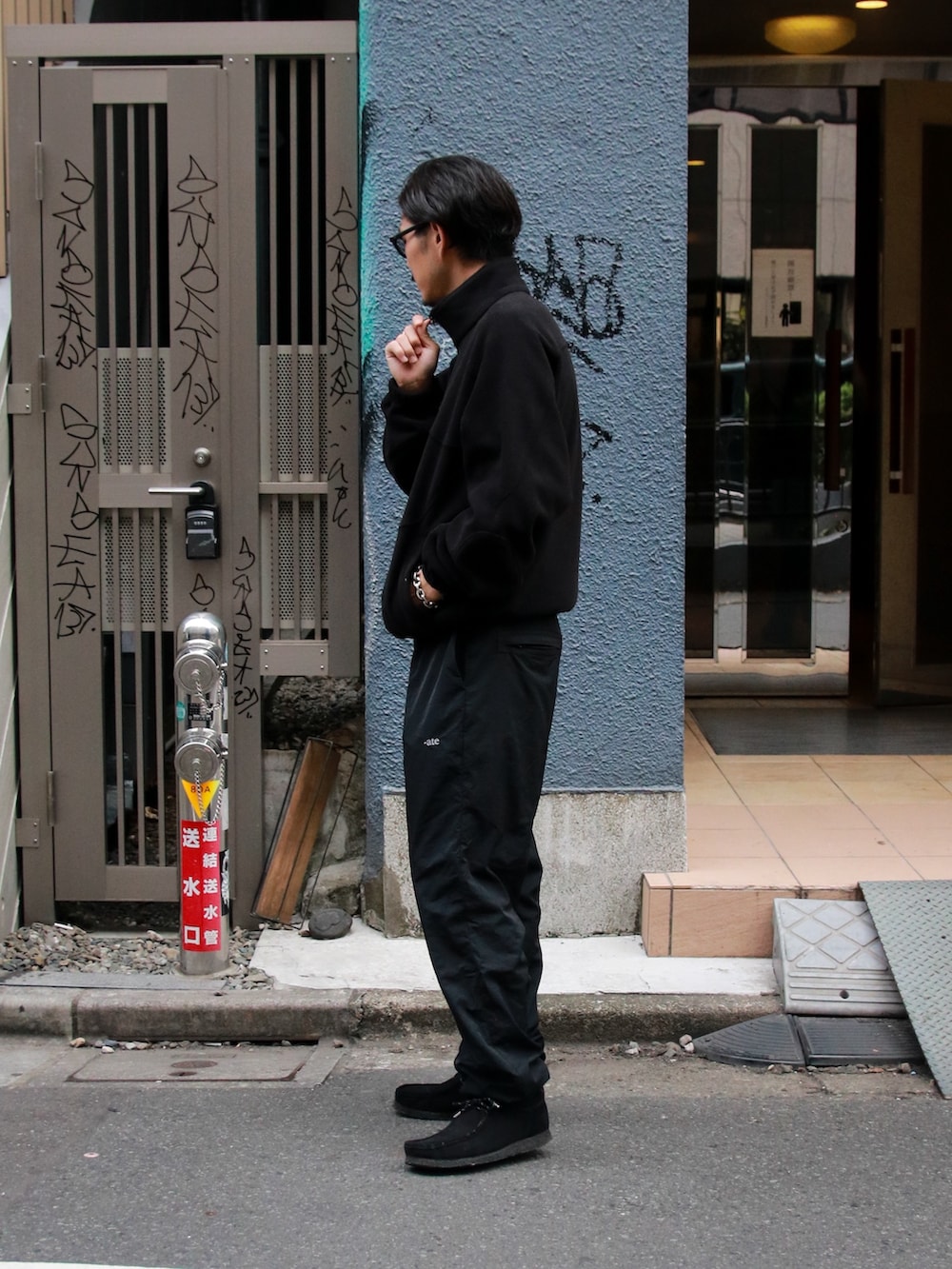 ブラック系のブルゾン、ブラック系のパンツ、ブラック系のブーツを着用したメンズの秋コーディネートの5枚目の写真