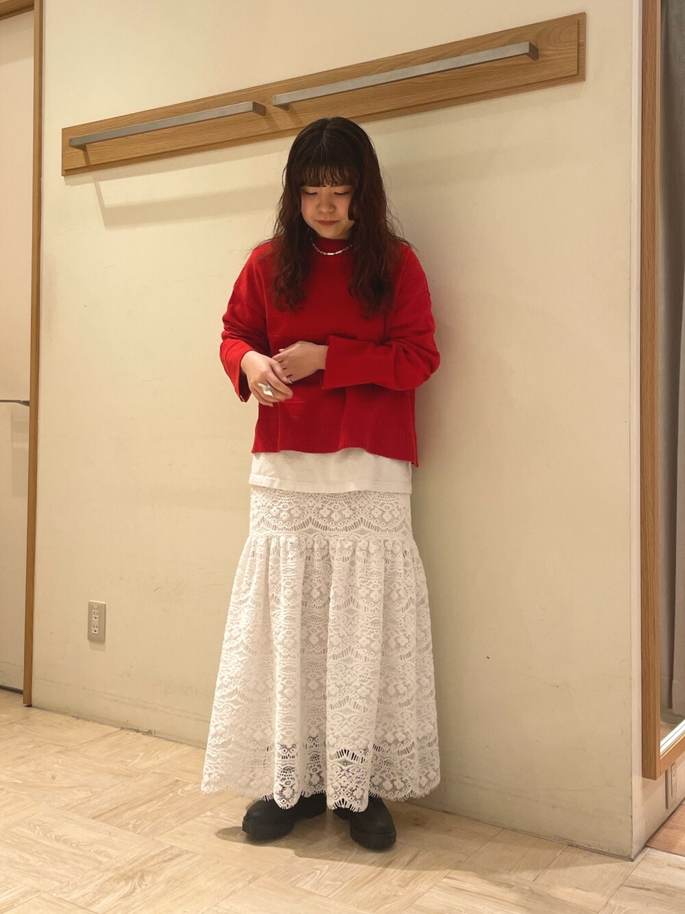 グリーン系のブルゾン、レッド系のニット/セーター、ホワイト系のスカートを着用したレディースの冬コーディネートの4枚目の写真