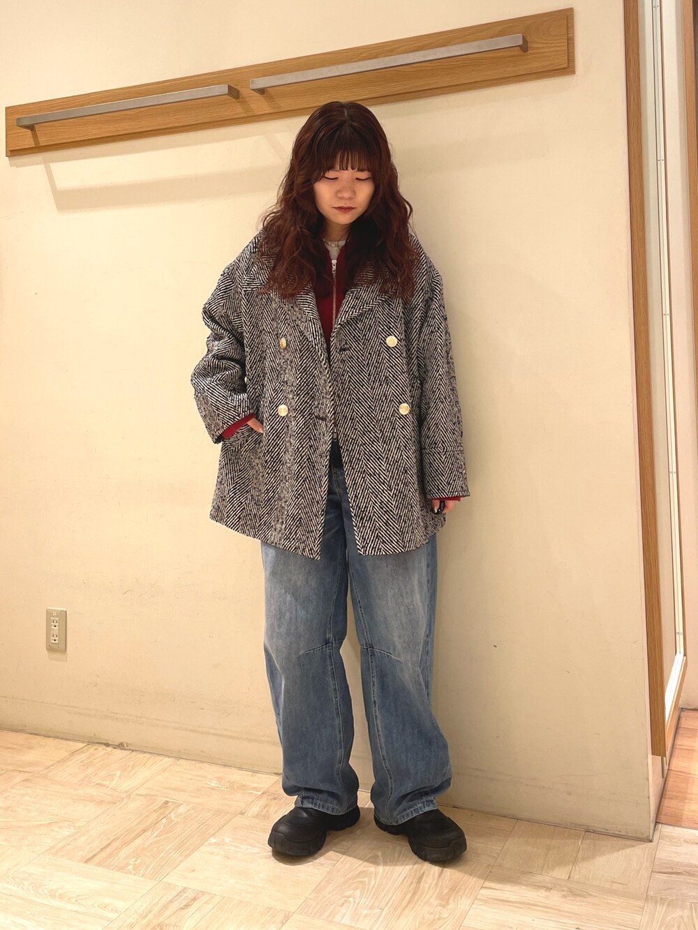 ブラック系のピーコート、レッド系のパーカーを着用したレディースの冬コーディネートの2枚目の写真