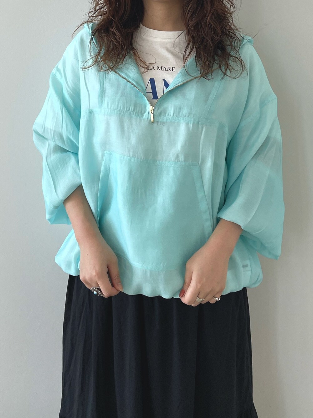 ブルー系のTシャツ/カットソー、ブラック系のスカート、ブラック系のサンダルを着用したレディースの春コーディネートの3枚目の写真