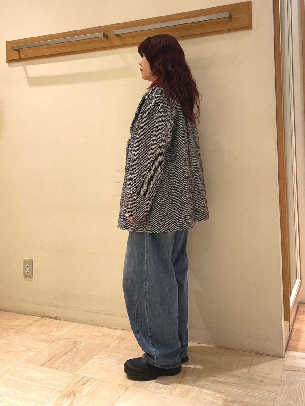 ブラック系のピーコート、レッド系のパーカーを着用したレディースの冬コーディネートの5枚目の写真