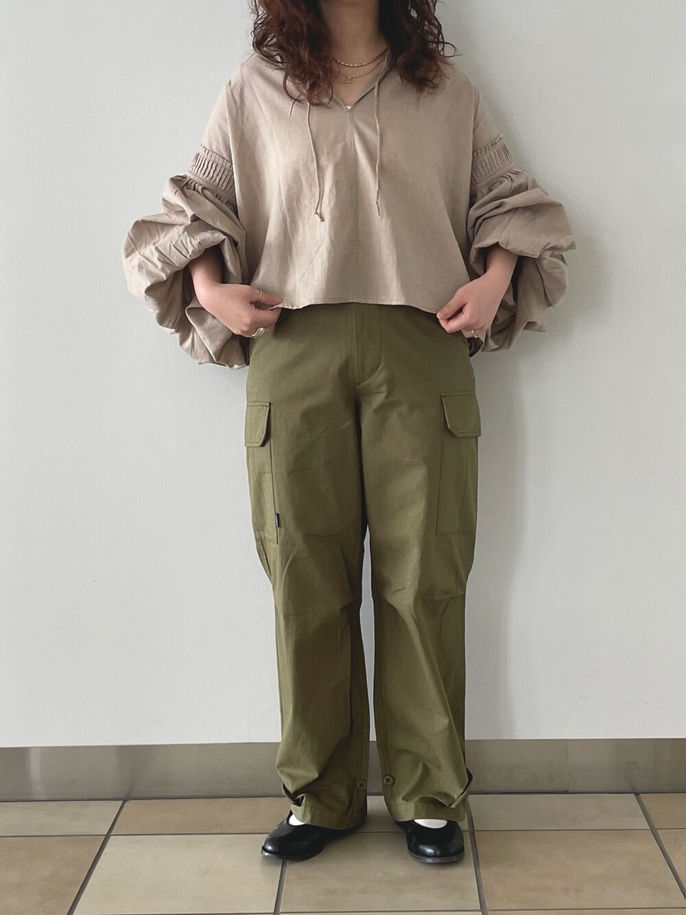 グリーン系のカーゴパンツ、ホワイト系のキャミソール、ベージュ系のシャツ/ブラウスを着用したレディースの春コーディネートの2枚目の写真