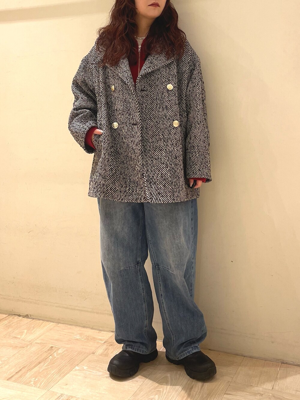 ブラック系のピーコート、レッド系のパーカーを着用したレディースの冬コーディネートの3枚目の写真