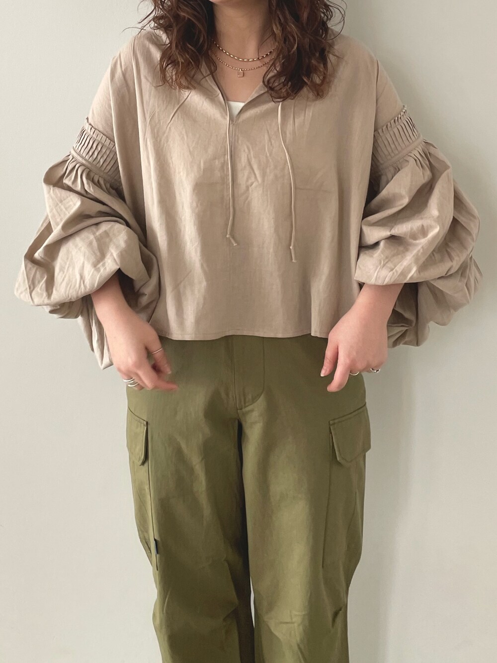 グリーン系のカーゴパンツ、ホワイト系のキャミソール、ベージュ系のシャツ/ブラウスを着用したレディースの春コーディネートの3枚目の写真