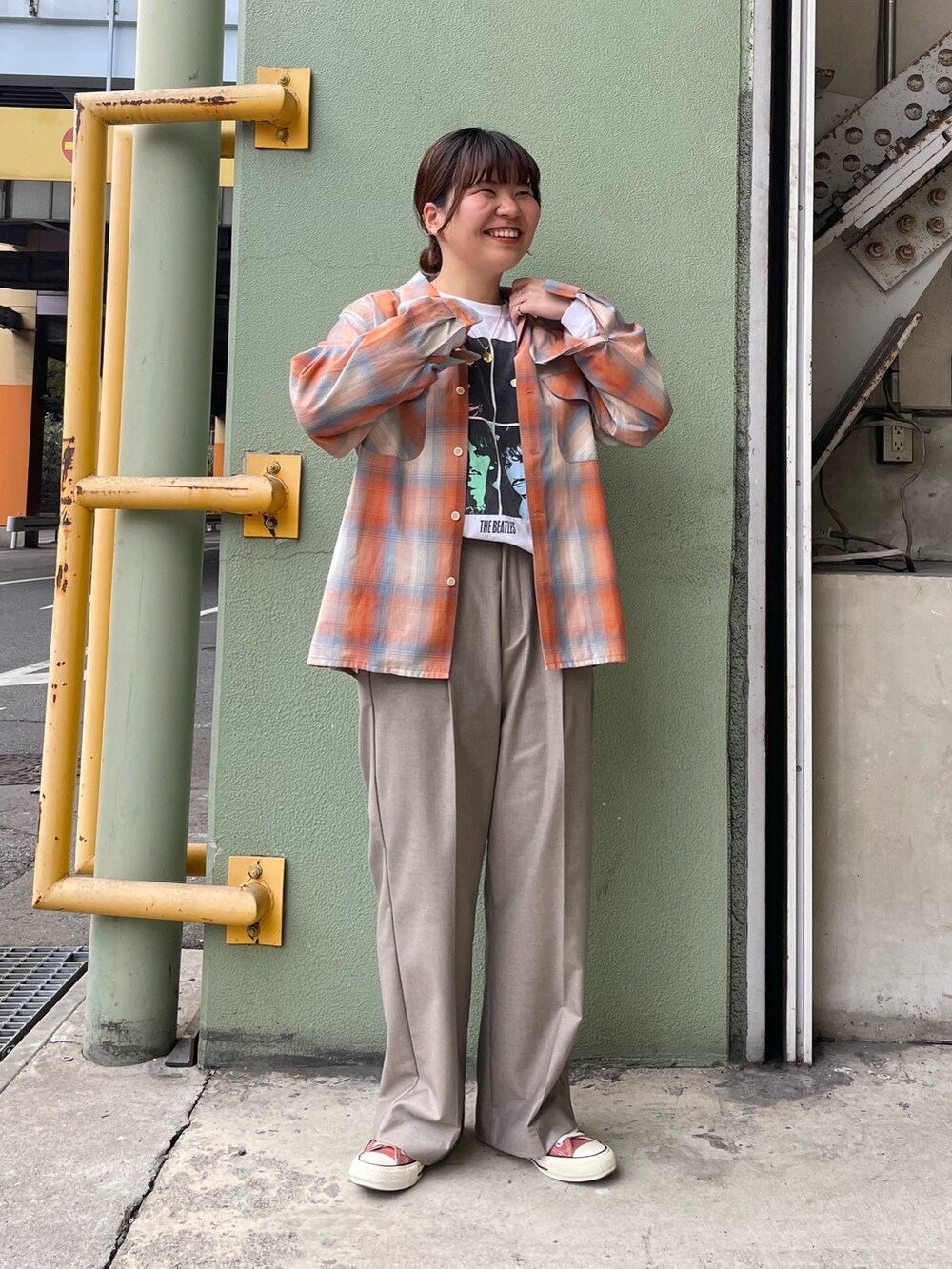 ホワイト系のTシャツ/カットソー、オレンジ系のシャツ/ブラウス、ベージュ系のスラックスを着用したレディースの冬コーディネートの2枚目の写真