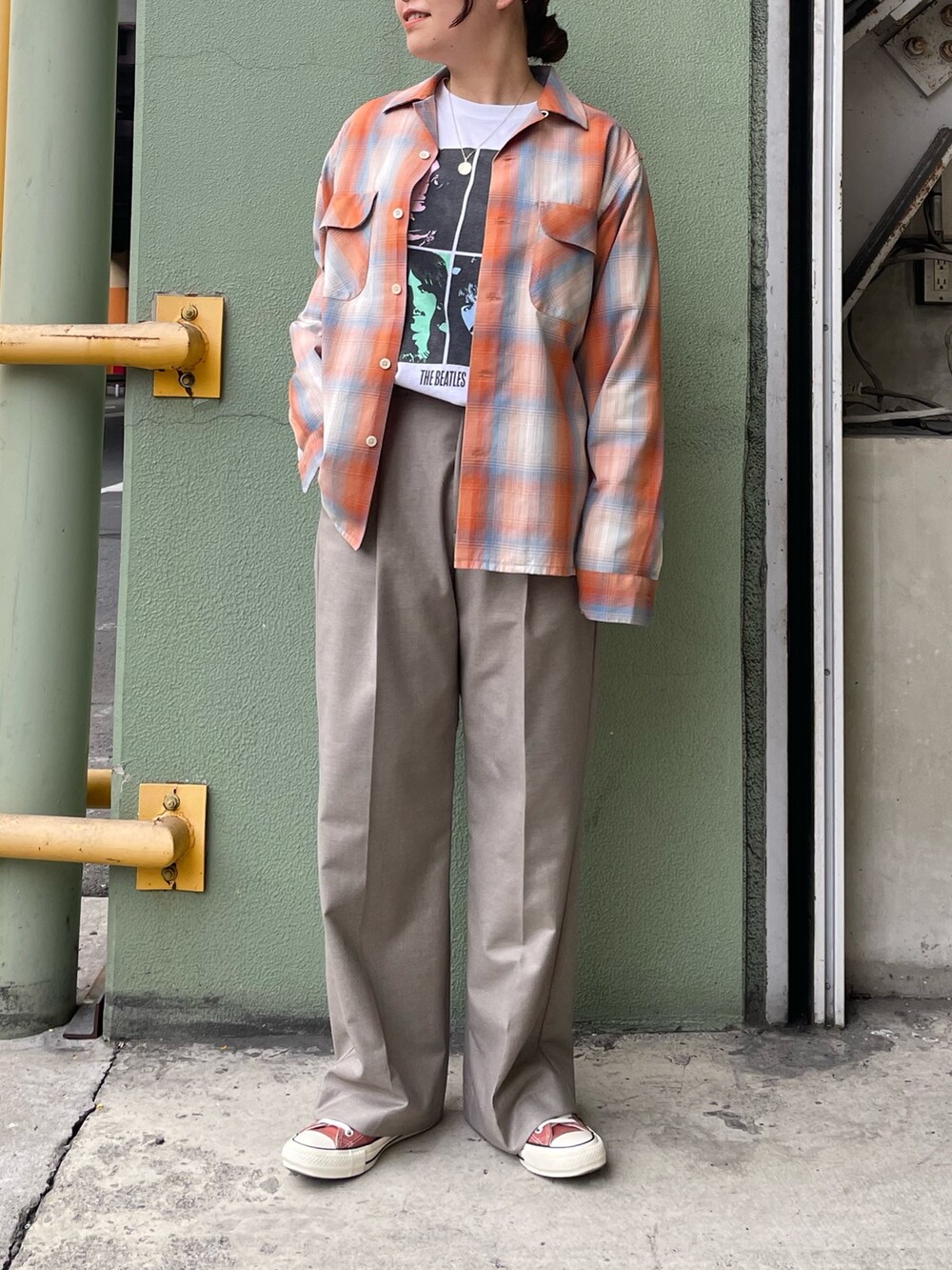 ホワイト系のTシャツ/カットソー、オレンジ系のシャツ/ブラウス、ベージュ系のスラックスを着用したレディースの冬コーディネートの3枚目の写真