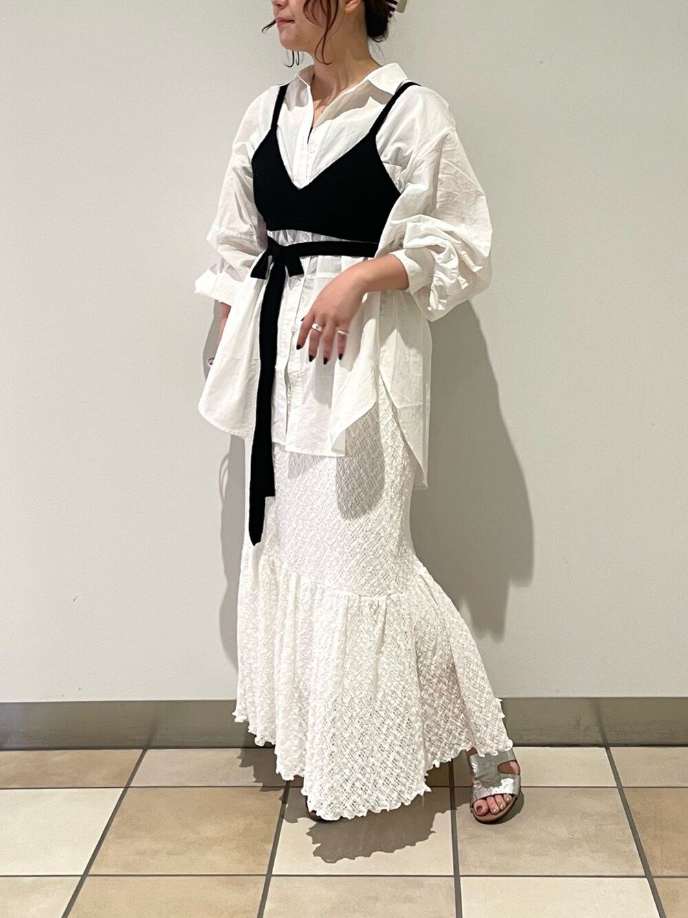 ブラック系のニット/セーター、ホワイト系のシャツ/ブラウス、ホワイト系のスカートを着用したレディースの夏コーディネートの2枚目の写真