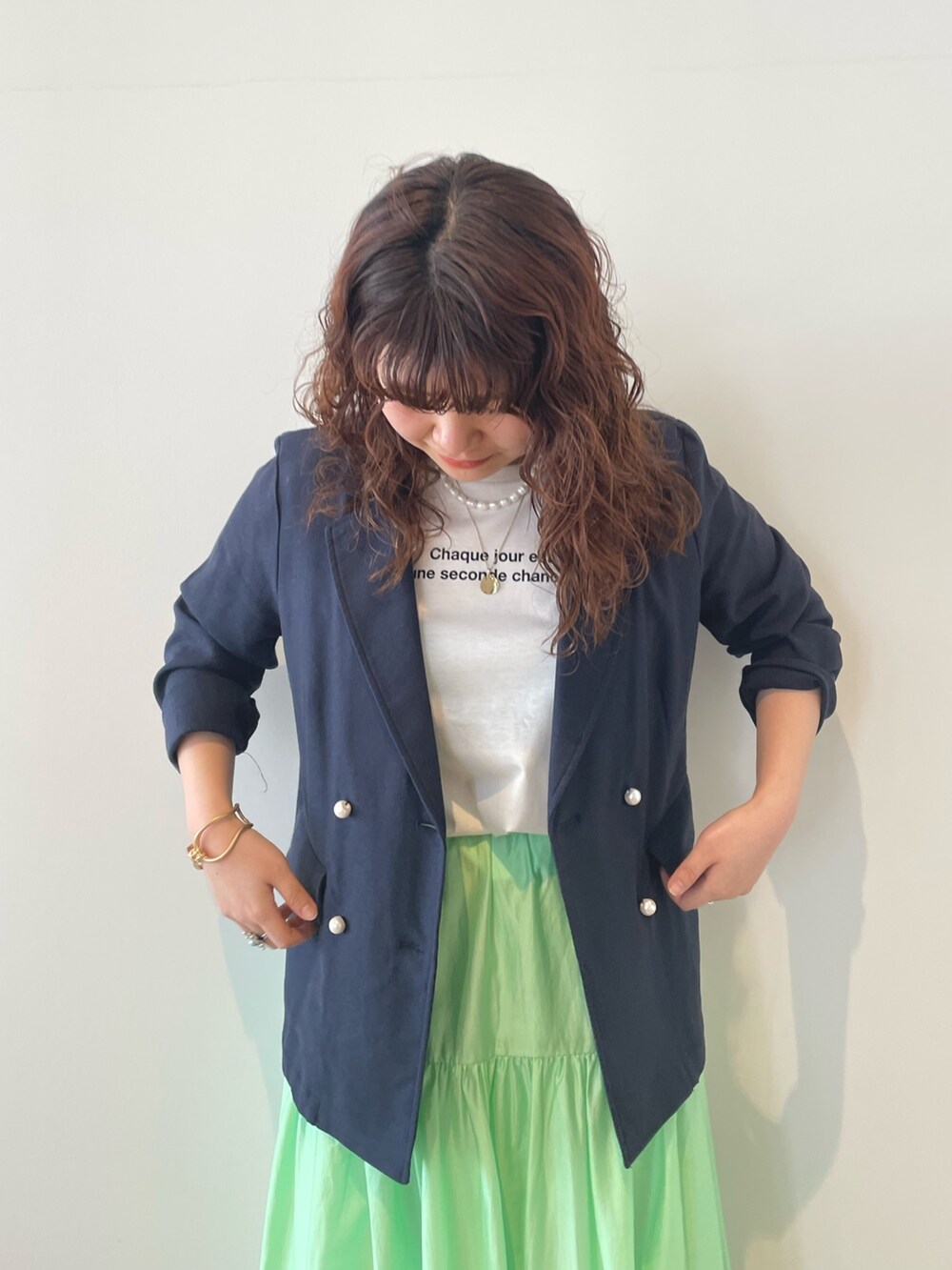 ブルー系のテーラードジャケット、ホワイト系のTシャツ/カットソー、グリーン系のスカートを着用したレディースの春コーディネートの4枚目の写真