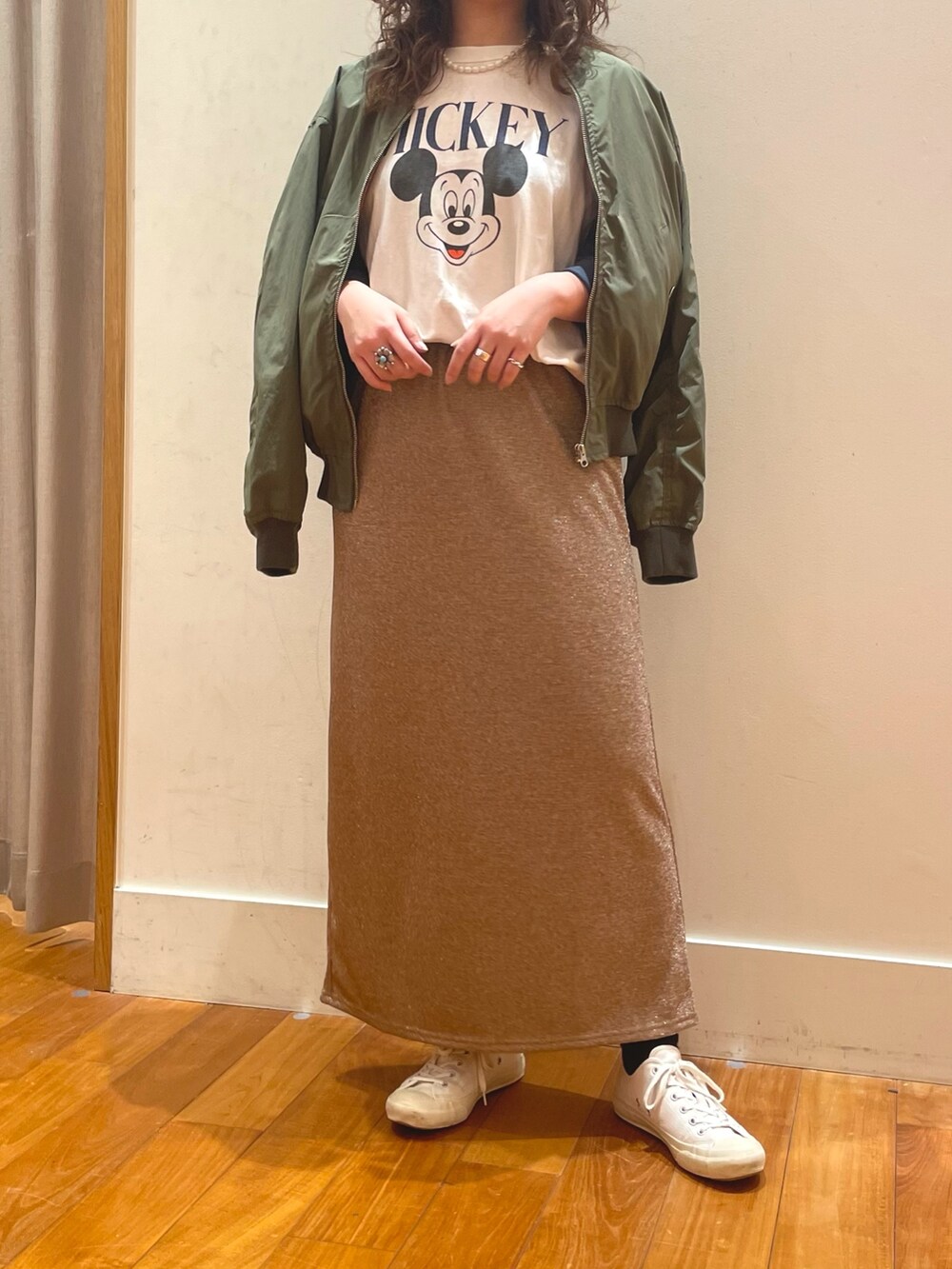 ホワイト系のTシャツ/カットソー、ベージュ系のスカート、グリーン系のブルゾンを着用したレディースの春コーディネートの2枚目の写真