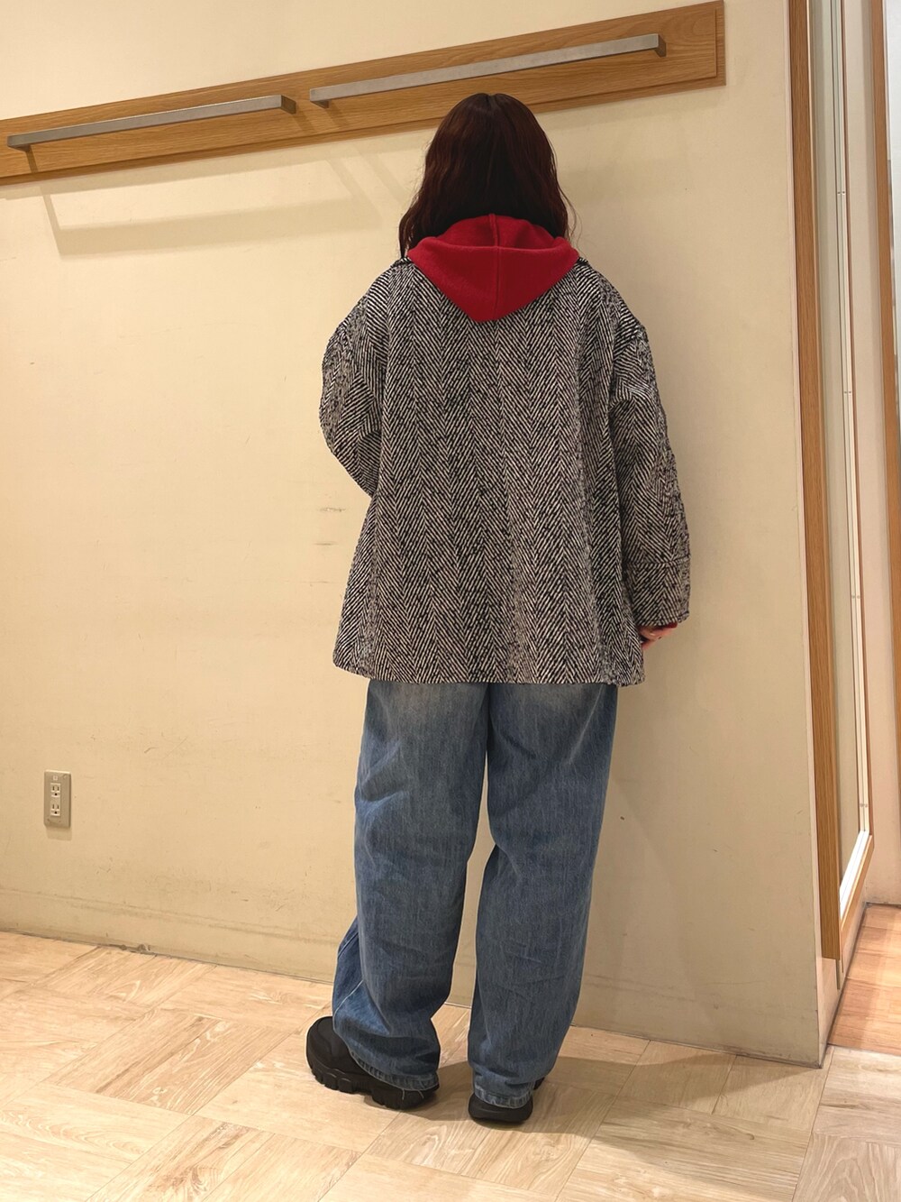 ブラック系のピーコート、レッド系のパーカーを着用したレディースの冬コーディネートの4枚目の写真