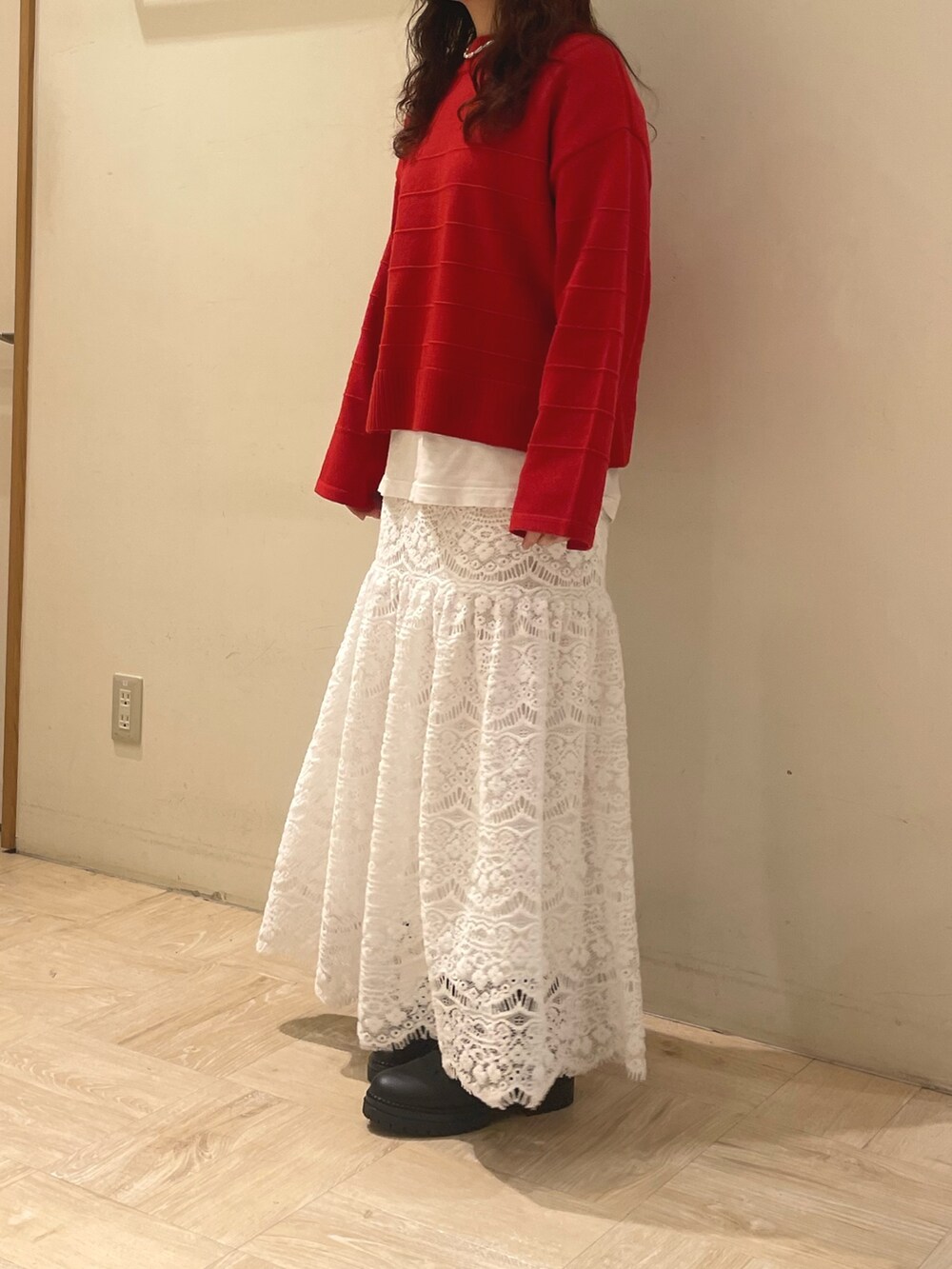 グリーン系のブルゾン、レッド系のニット/セーター、ホワイト系のスカートを着用したレディースの冬コーディネートの5枚目の写真