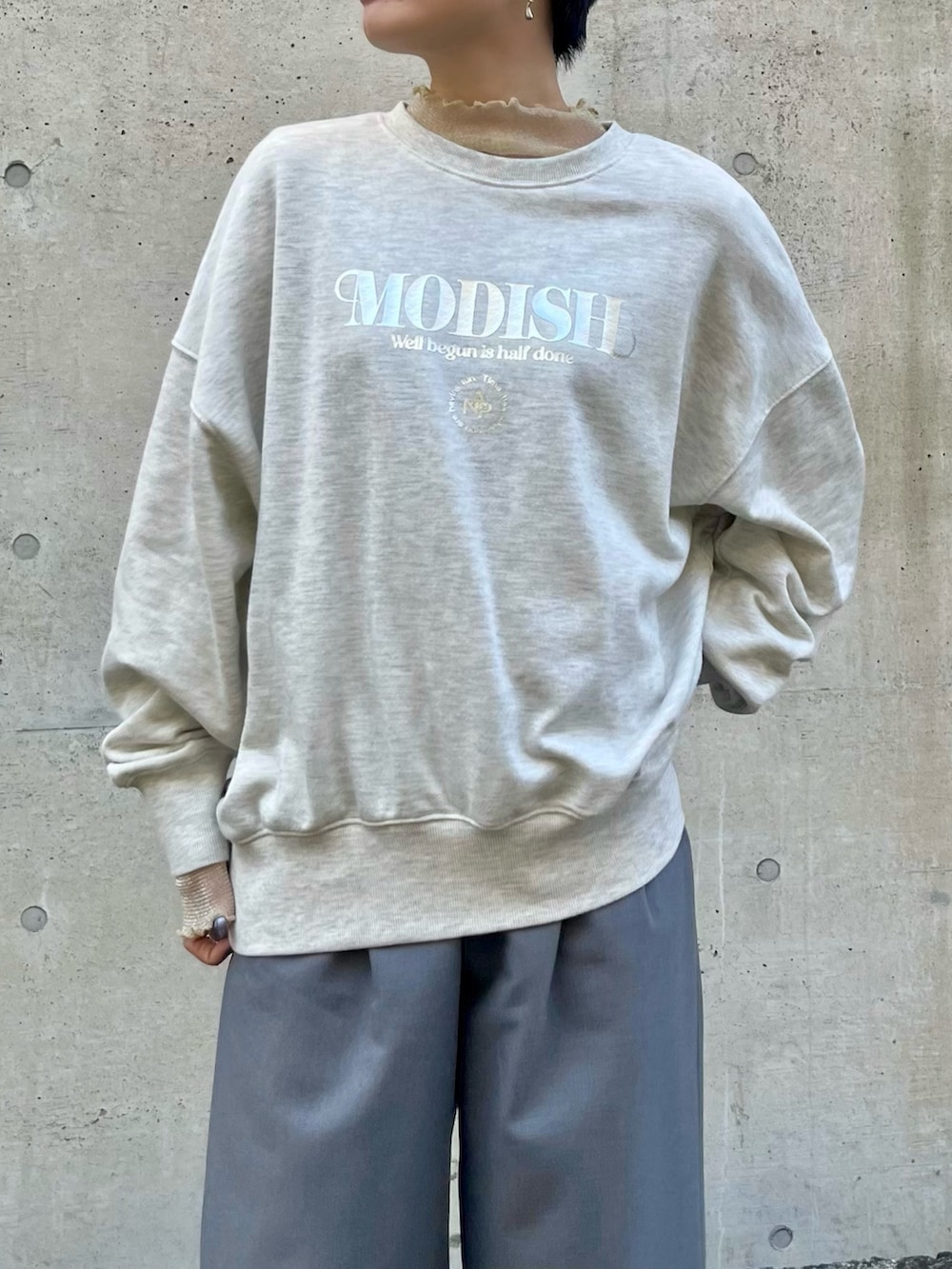 グレー系のスウェット、ホワイト系のTシャツ/カットソー、グレー系のスラックスを着用したレディースの冬コーディネートの2枚目の写真