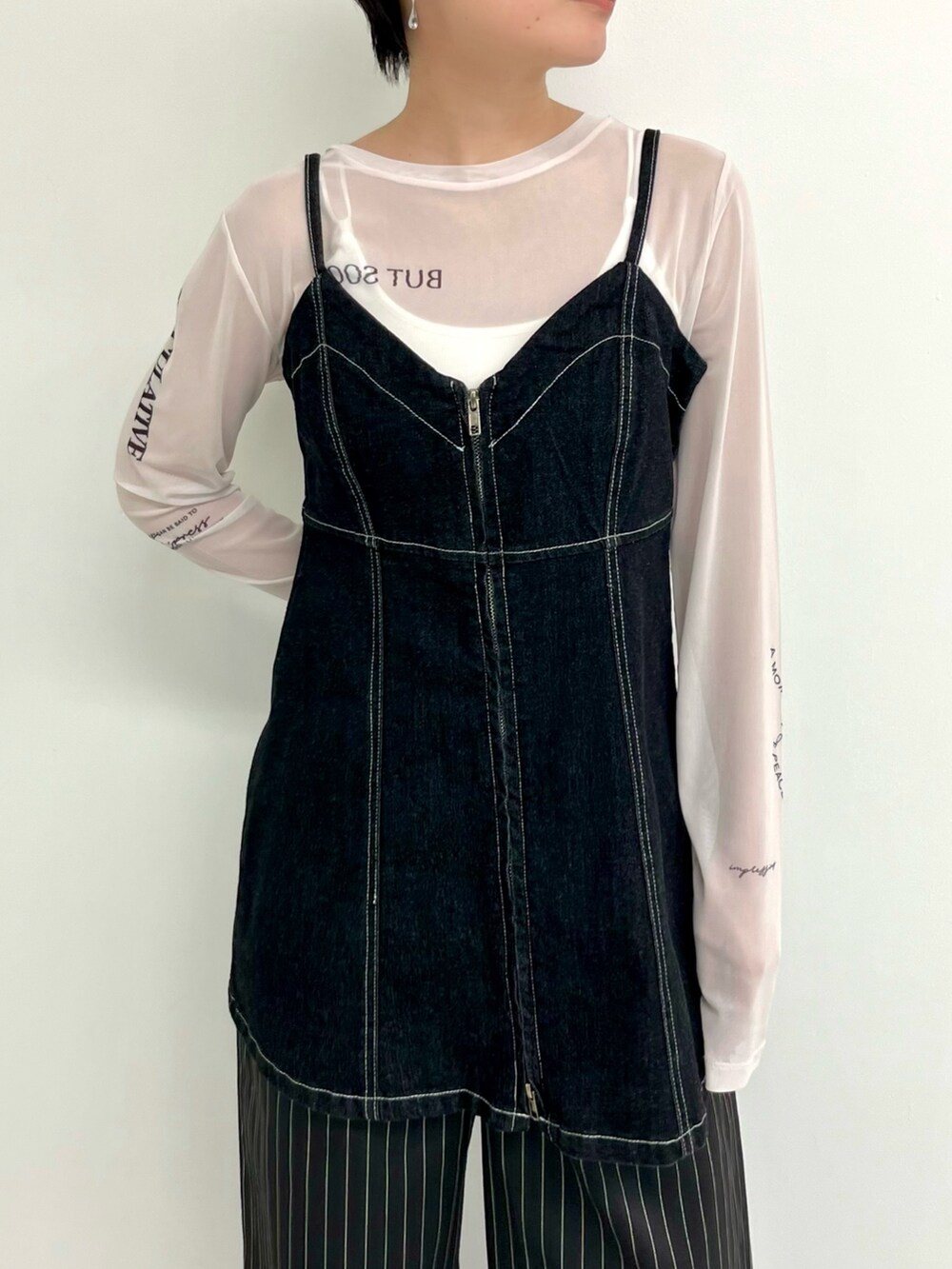 ホワイト系のキャミソール、ブラック系のスラックス、ブラック系のパンプスを着用したレディースの春コーディネートの2枚目の写真