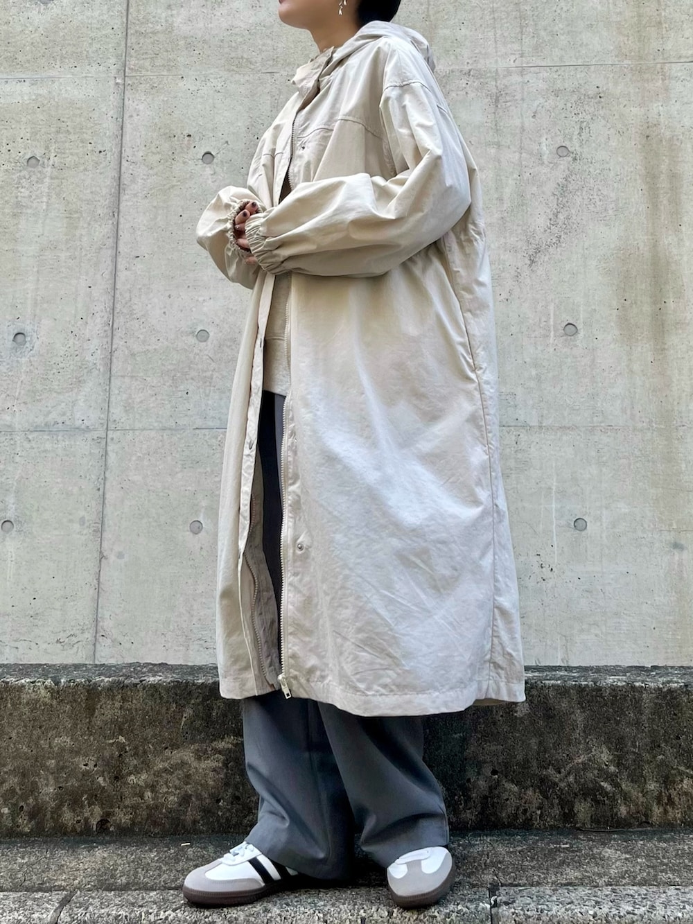 グレー系のスウェット、ホワイト系のTシャツ/カットソー、グレー系のスラックスを着用したレディースの冬コーディネートの3枚目の写真