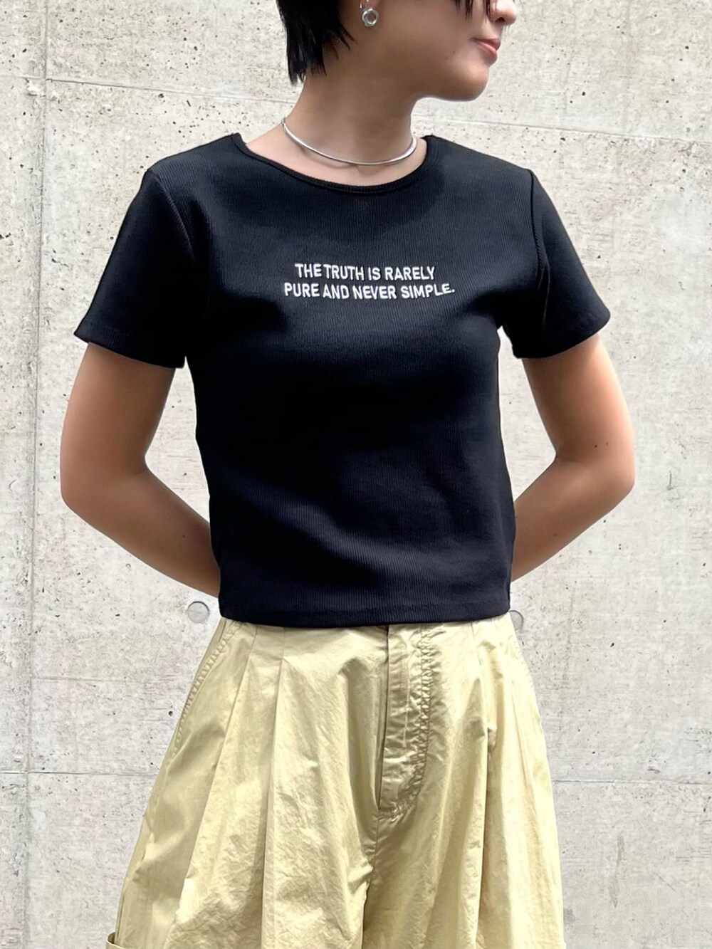ブラック系のTシャツ/カットソー、ベージュ系のその他パンツ、ブラック系のパンプスを着用したレディースの春コーディネートの2枚目の写真