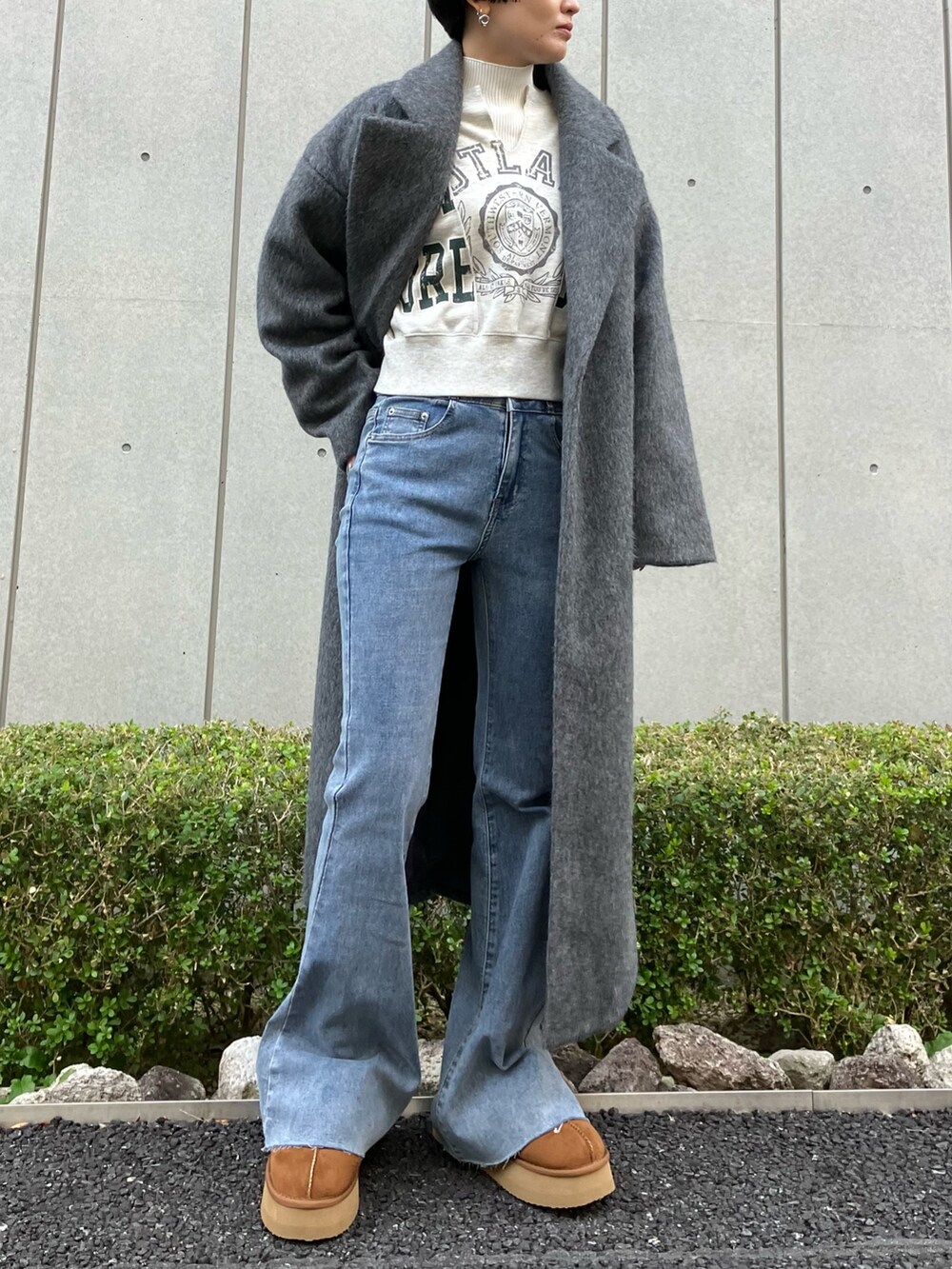ブルー系のデニムパンツ、グレー系のチェスターコート、ホワイト系のスウェットを着用したレディースの冬コーディネートの2枚目の写真