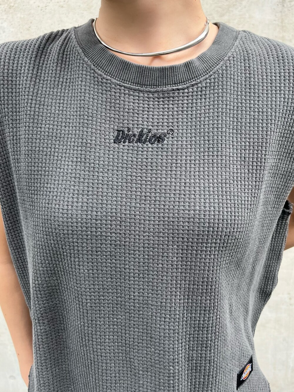 グレー系のトップス、ブルー系のデニムパンツ、シルバー系のパンプスを着用したレディースの春コーディネートの3枚目の写真