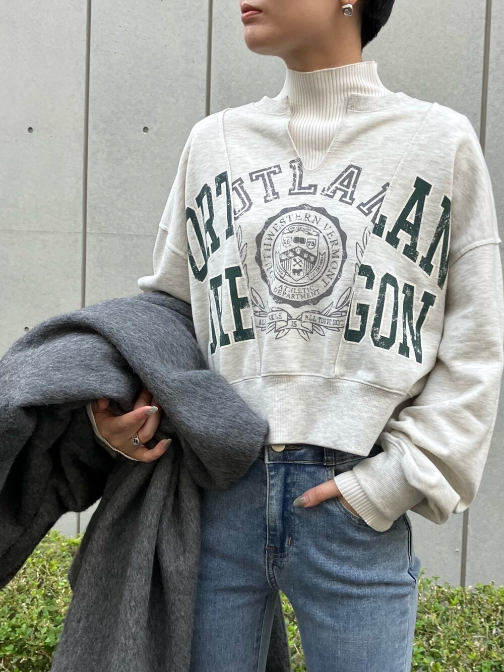ブルー系のデニムパンツ、グレー系のチェスターコート、ホワイト系のスウェットを着用したレディースの冬コーディネートの3枚目の写真