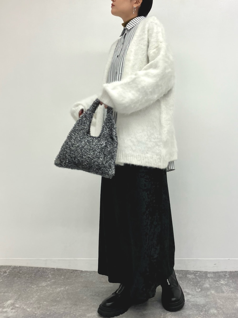 ホワイト系のカーディガン/ボレロ、ブルー系のシャツ/ブラウス、ブラック系のスカートを着用したレディースの冬コーディネートの3枚目の写真