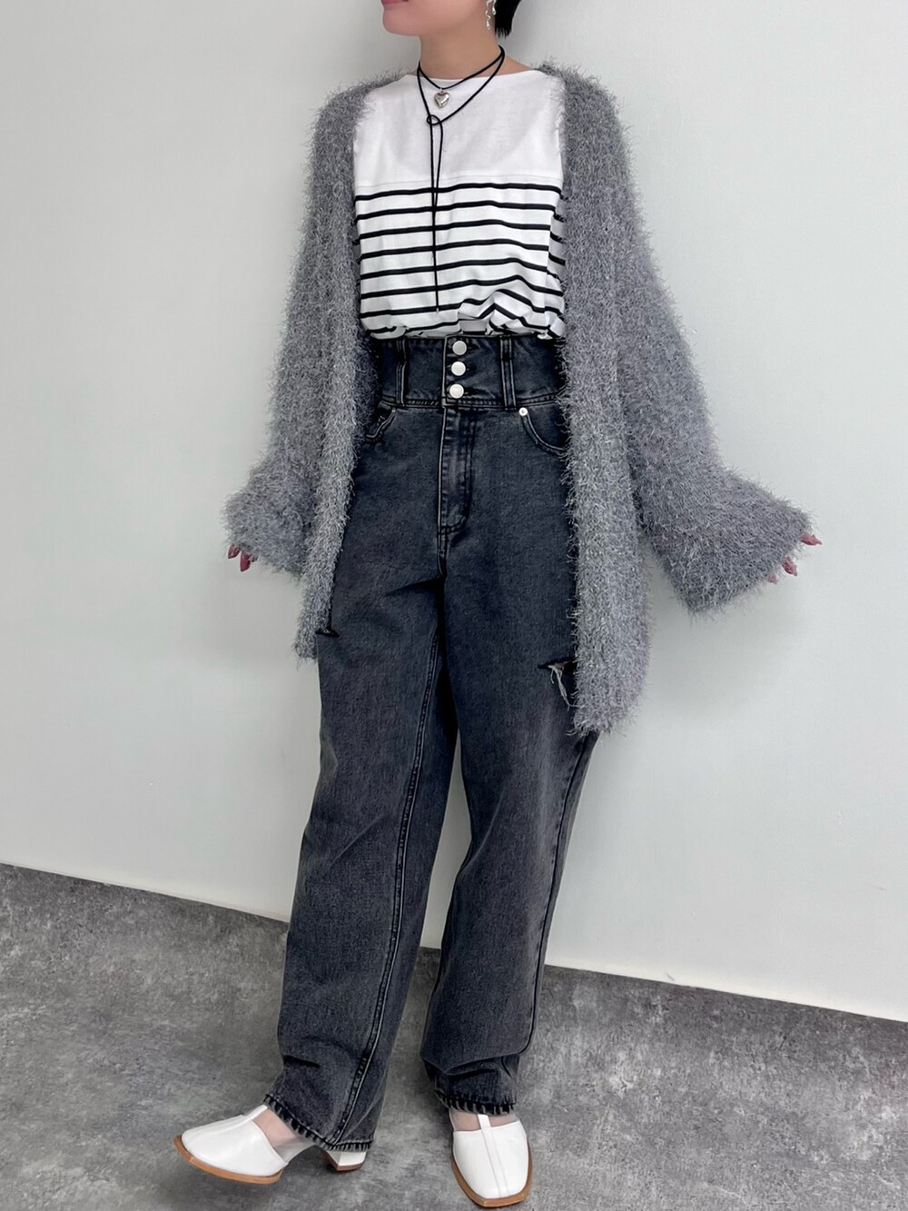 グレー系のカーディガン/ボレロ、ブラック系のデニムパンツ、ホワイト系のTシャツ/カットソーを着用したレディースの冬コーディネートの2枚目の写真