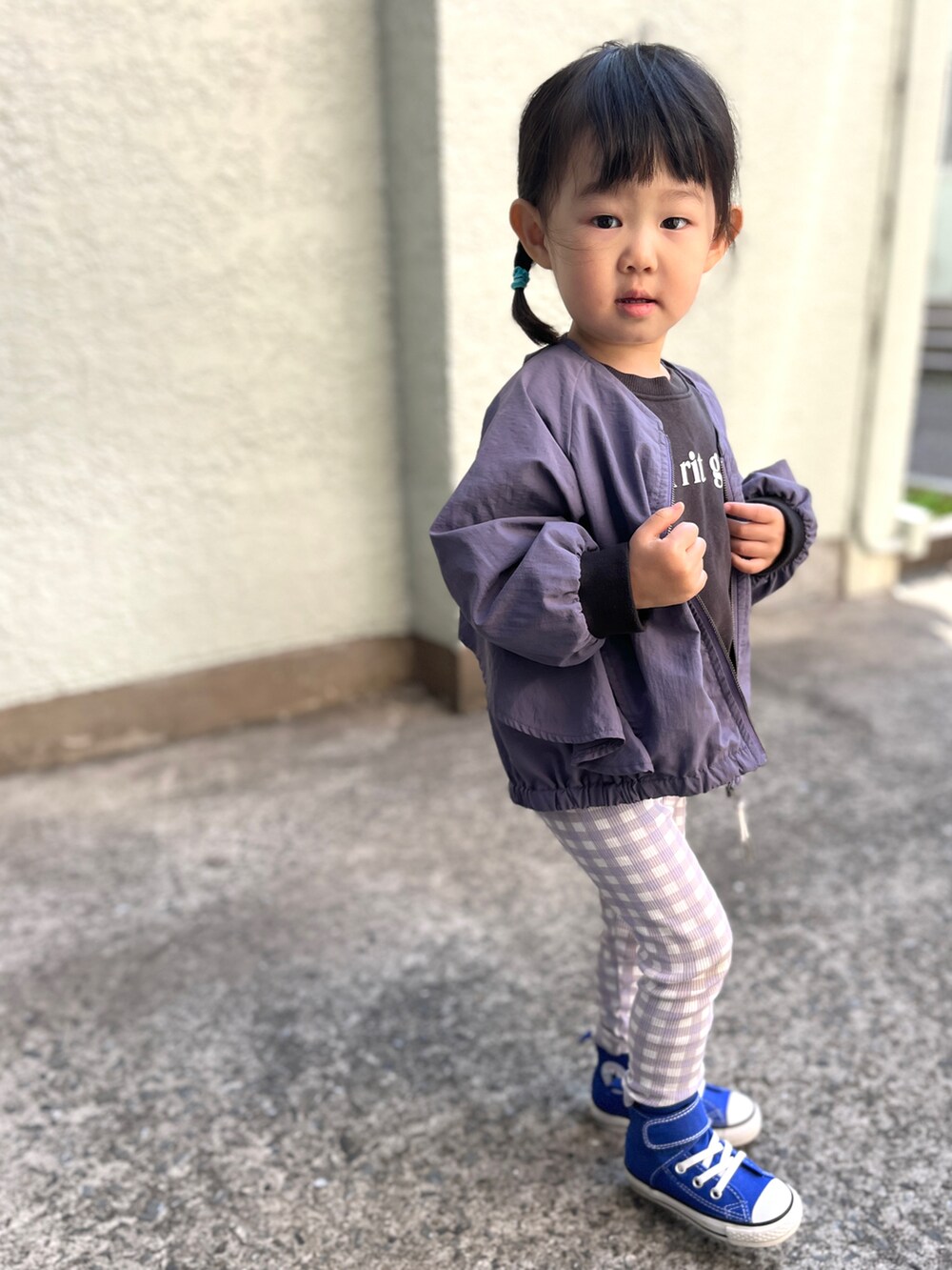 パープル系のブルゾン、ブラック系のスウェット、ブルー系のスニーカーを着用したキッズの春コーディネートの3枚目の写真