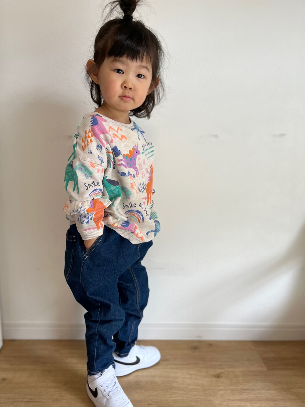 ブルー系のデニムパンツ、ホワイト系のスニーカー、ベージュ系のスウェットを着用したキッズの春コーディネートの2枚目の写真