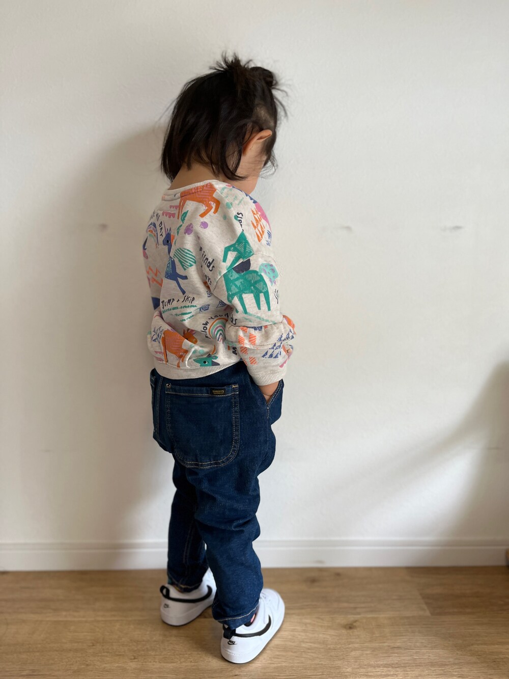 ブルー系のデニムパンツ、ホワイト系のスニーカー、ベージュ系のスウェットを着用したキッズの春コーディネートの3枚目の写真