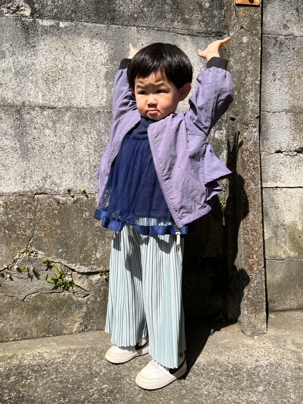 ブルー系のその他パンツ、ホワイト系のスニーカー、パープル系のブルゾンを着用したキッズの春コーディネートの2枚目の写真