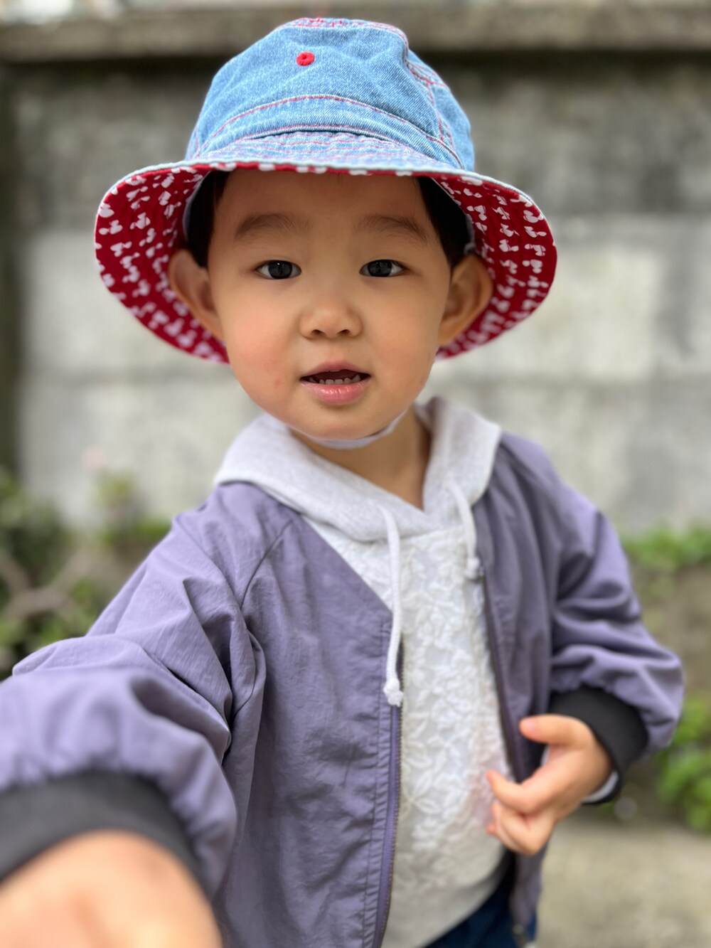 ホワイト系のパーカー、パープル系のブルゾン、ブルー系のデニムパンツを着用したキッズの春コーディネートの5枚目の写真