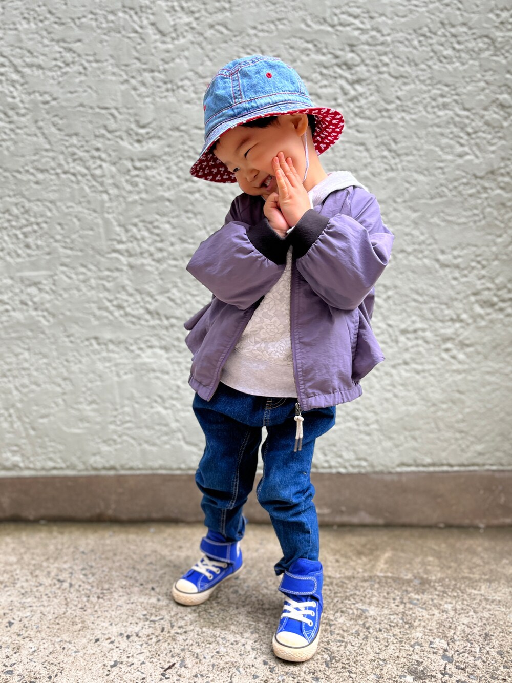 ホワイト系のパーカー、パープル系のブルゾン、ブルー系のデニムパンツを着用したキッズの春コーディネートの2枚目の写真