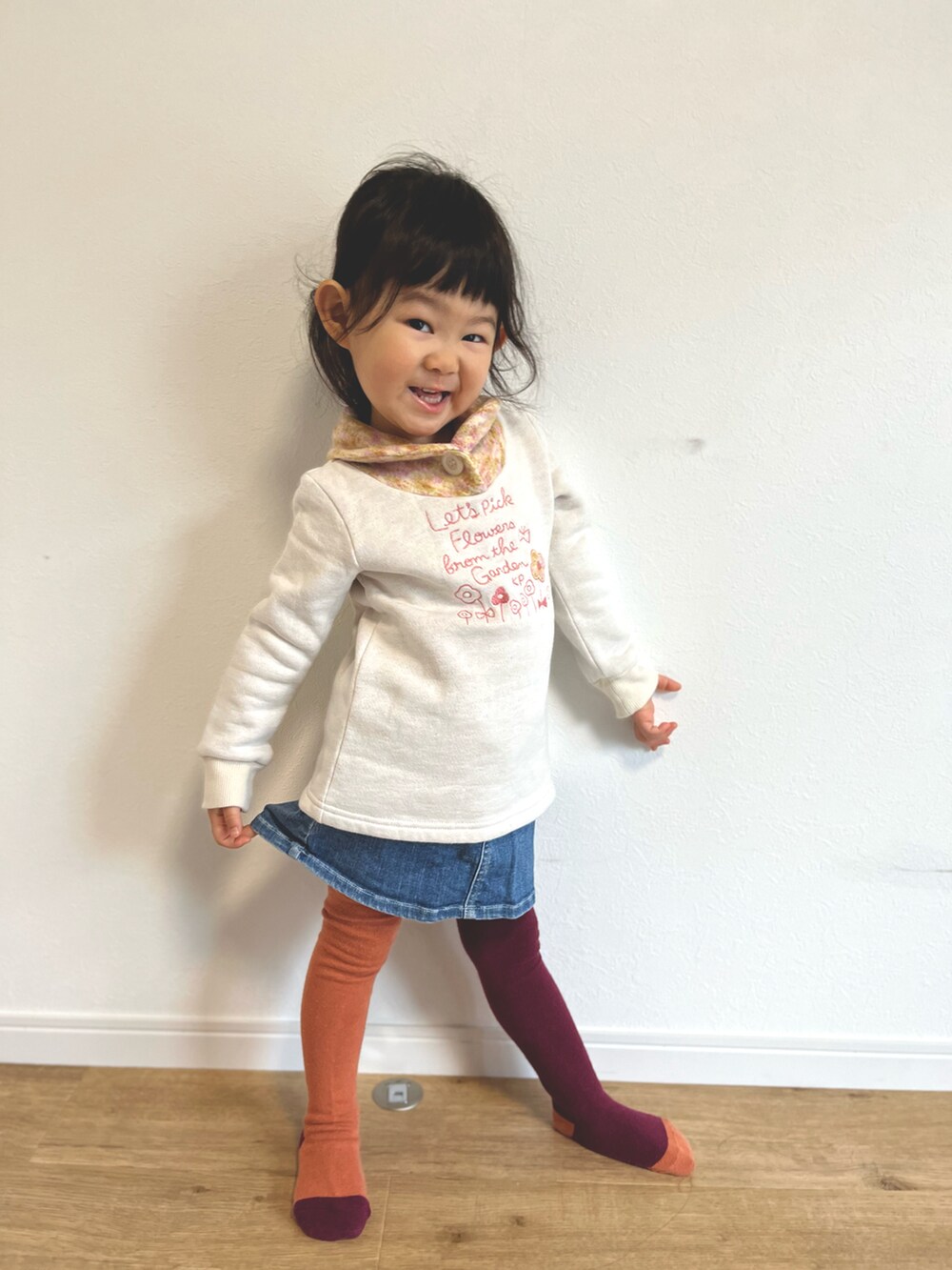ベージュ系のトップス、ブルー系のデニムスカートを着用したキッズの冬コーディネートの2枚目の写真