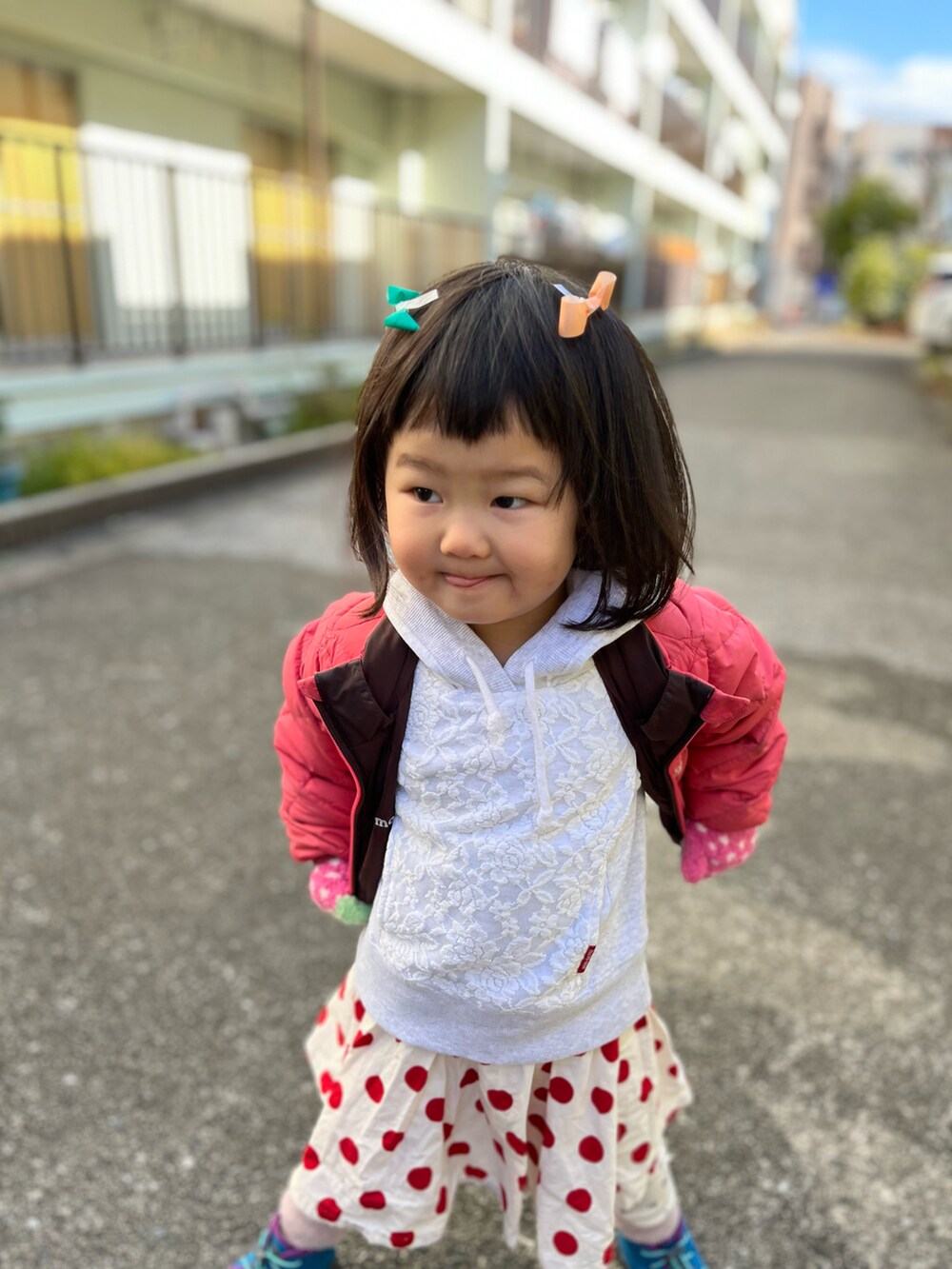 ピンク系のジャケット/アウター、レッド系のスカート、ブルー系のスニーカーを着用したキッズの冬コーディネートの2枚目の写真