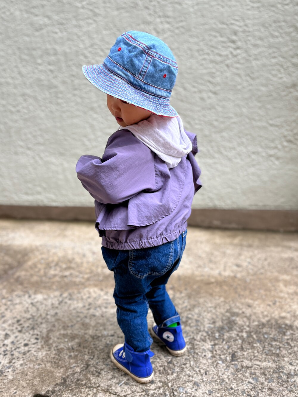 ホワイト系のパーカー、パープル系のブルゾン、ブルー系のデニムパンツを着用したキッズの春コーディネートの4枚目の写真