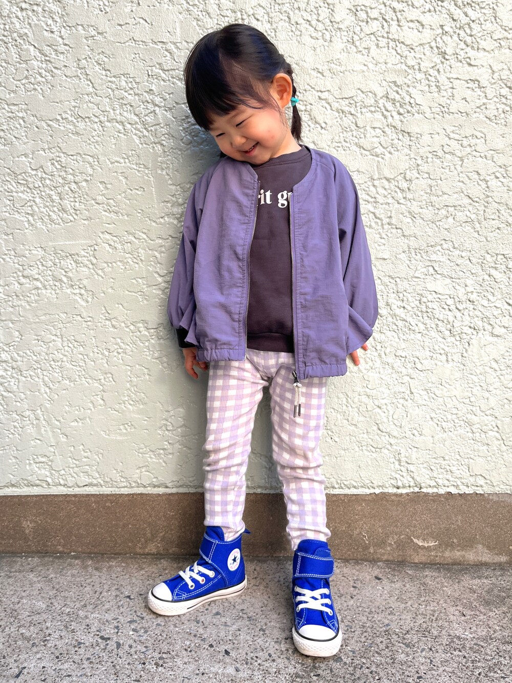 パープル系のブルゾン、ブラック系のスウェット、ブルー系のスニーカーを着用したキッズの春コーディネートの2枚目の写真