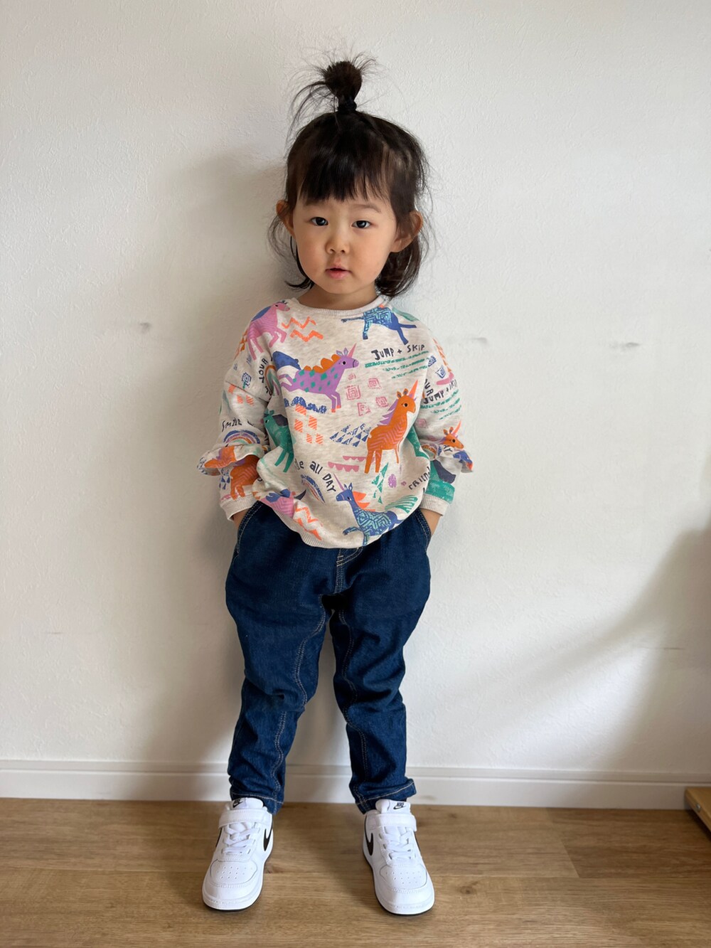 ブルー系のデニムパンツ、ホワイト系のスニーカー、ベージュ系のスウェットを着用したキッズの春コーディネートの4枚目の写真