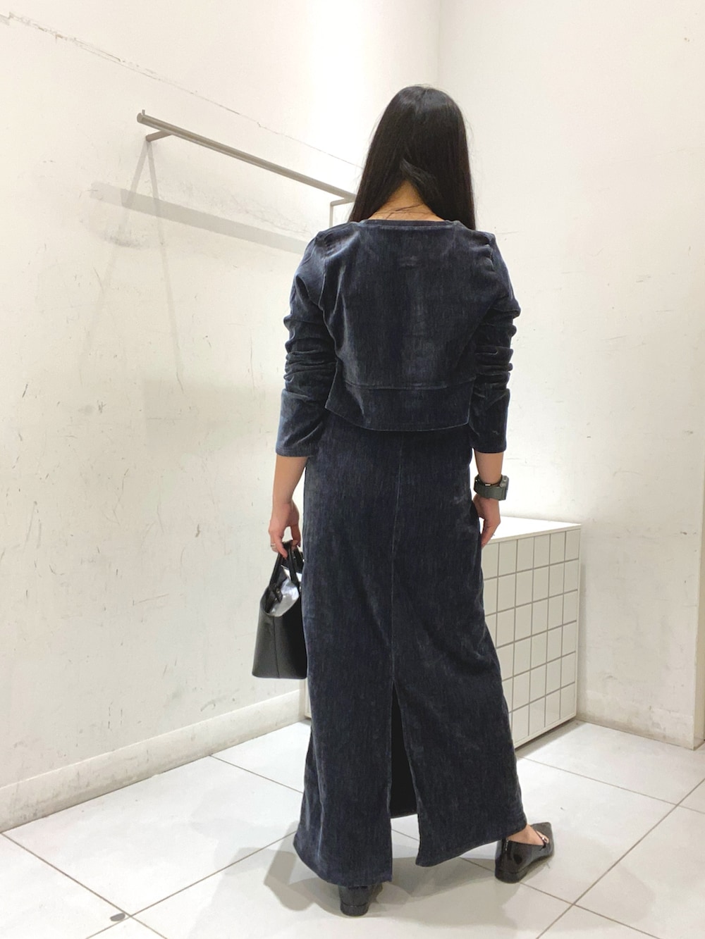 ブルー系のワンピース、ブラック系のトートバッグ、ブラック系のパンプスを着用したレディースの冬コーディネートの3枚目の写真