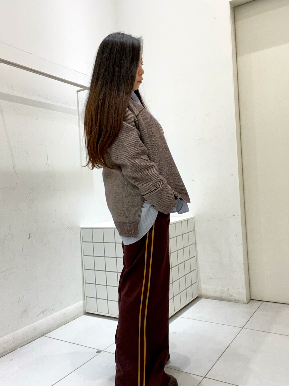 ブラウン系のニット/セーター、ブルー系のシャツ/ブラウス、ブラウン系のその他パンツを着用したレディースの秋コーディネートの2枚目の写真