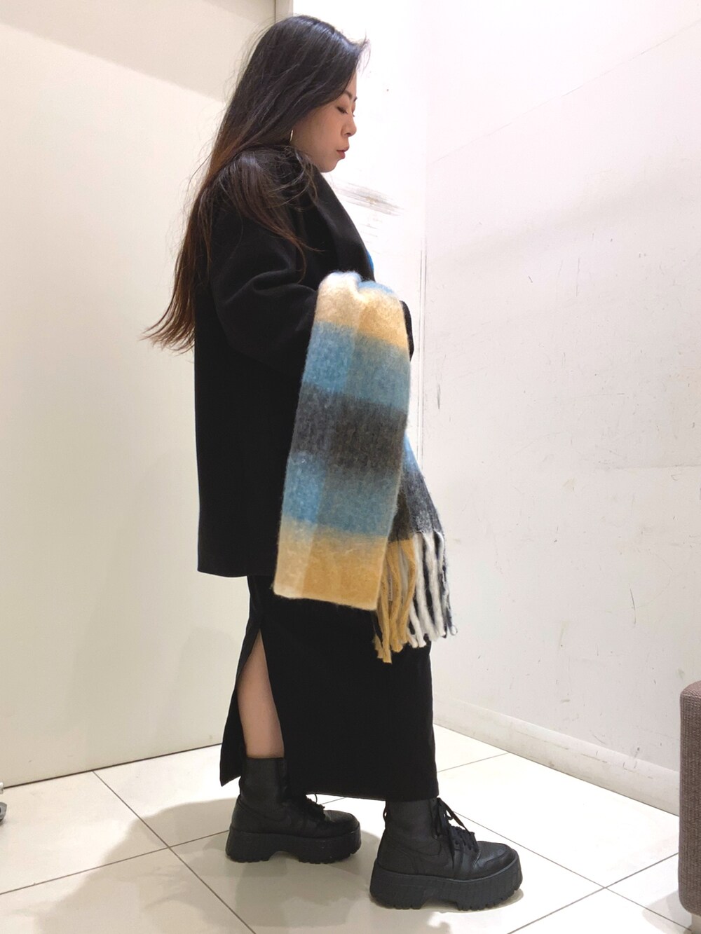 ブルー系のニット/セーター、ブラック系のスカート、ブラック系のその他アウターを着用したレディースの冬コーディネートの3枚目の写真