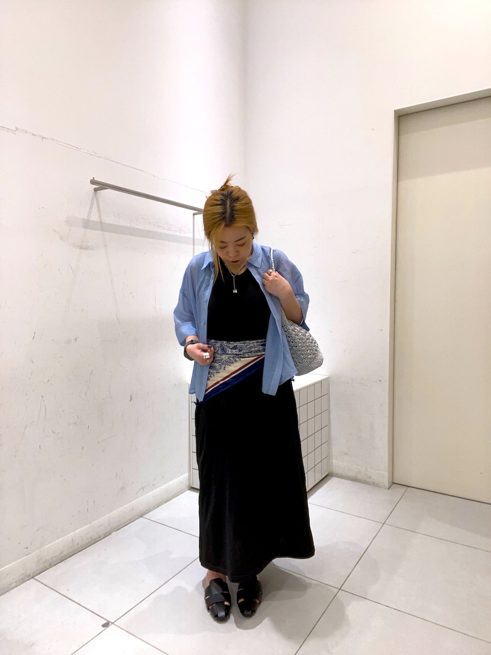 ブルー系のシャツ/ブラウス、ブラック系のサンダル、シルバー系のかごバッグを着用したレディースの春コーディネートの2枚目の写真
