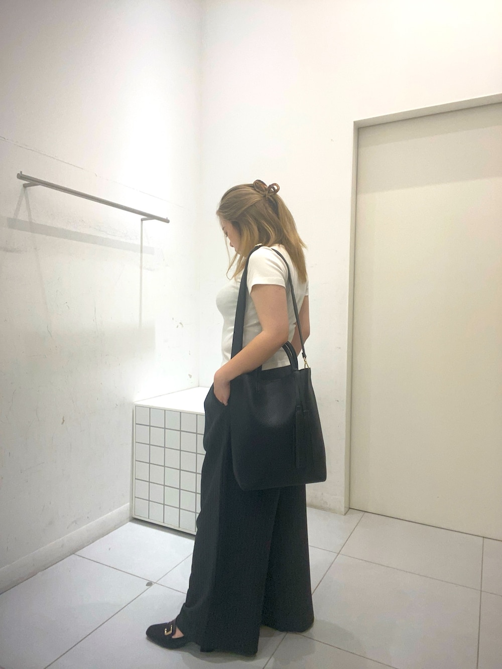ホワイト系のTシャツ/カットソー、グレー系のスラックス、ブラック系のトートバッグを着用したレディースの夏コーディネートの2枚目の写真