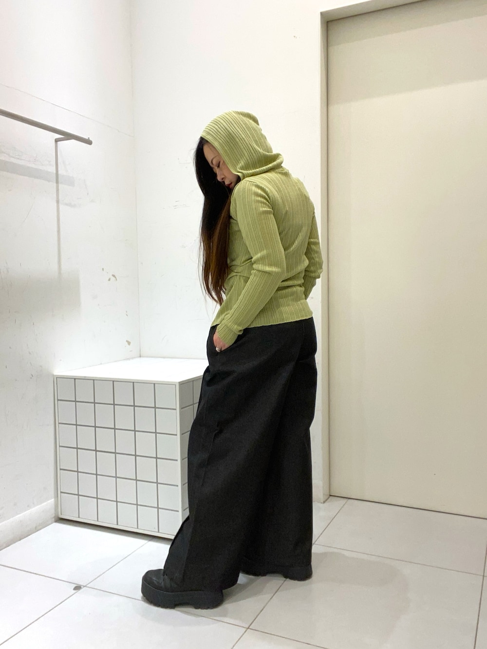 ベージュ系のニット/セーター、ブラック系のデニムパンツを着用したレディースの春コーディネートの2枚目の写真