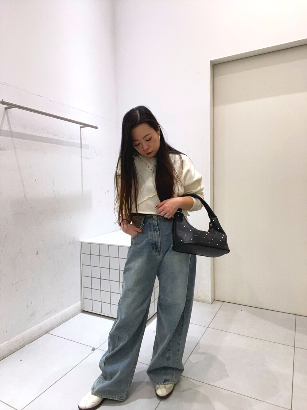 ホワイト系のスウェット、ブルー系のデニムパンツ、ブルー系のデニムパンツを着用したレディースの冬コーディネートの2枚目の写真