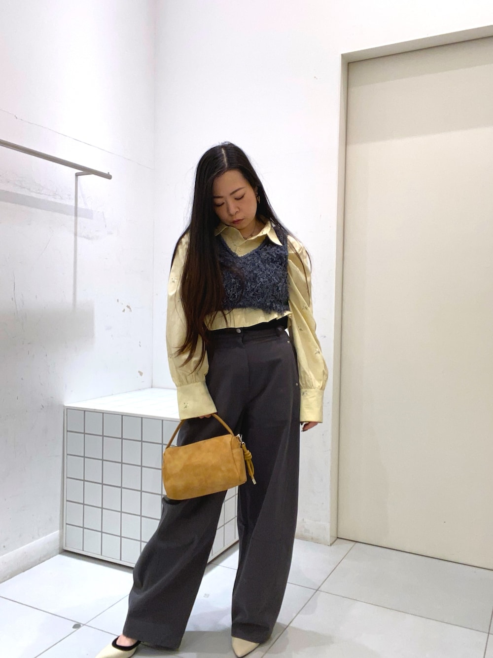 グレー系のベスト、ベージュ系のシャツ/ブラウス、グレー系のその他パンツを着用したレディースの冬コーディネートの2枚目の写真