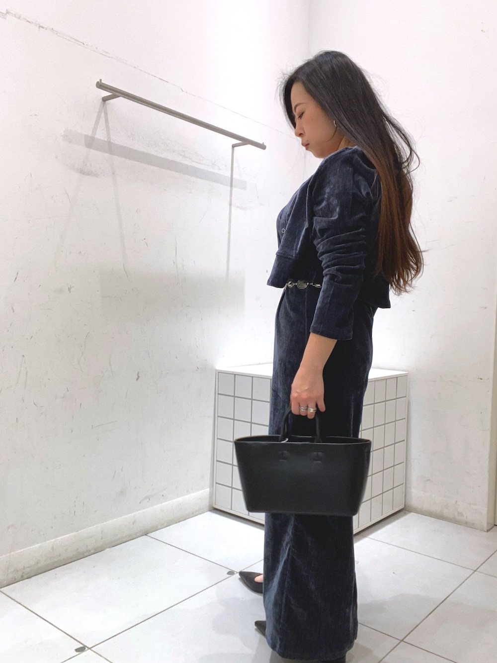 ブルー系のワンピース、ブラック系のトートバッグ、ブラック系のパンプスを着用したレディースの冬コーディネートの2枚目の写真