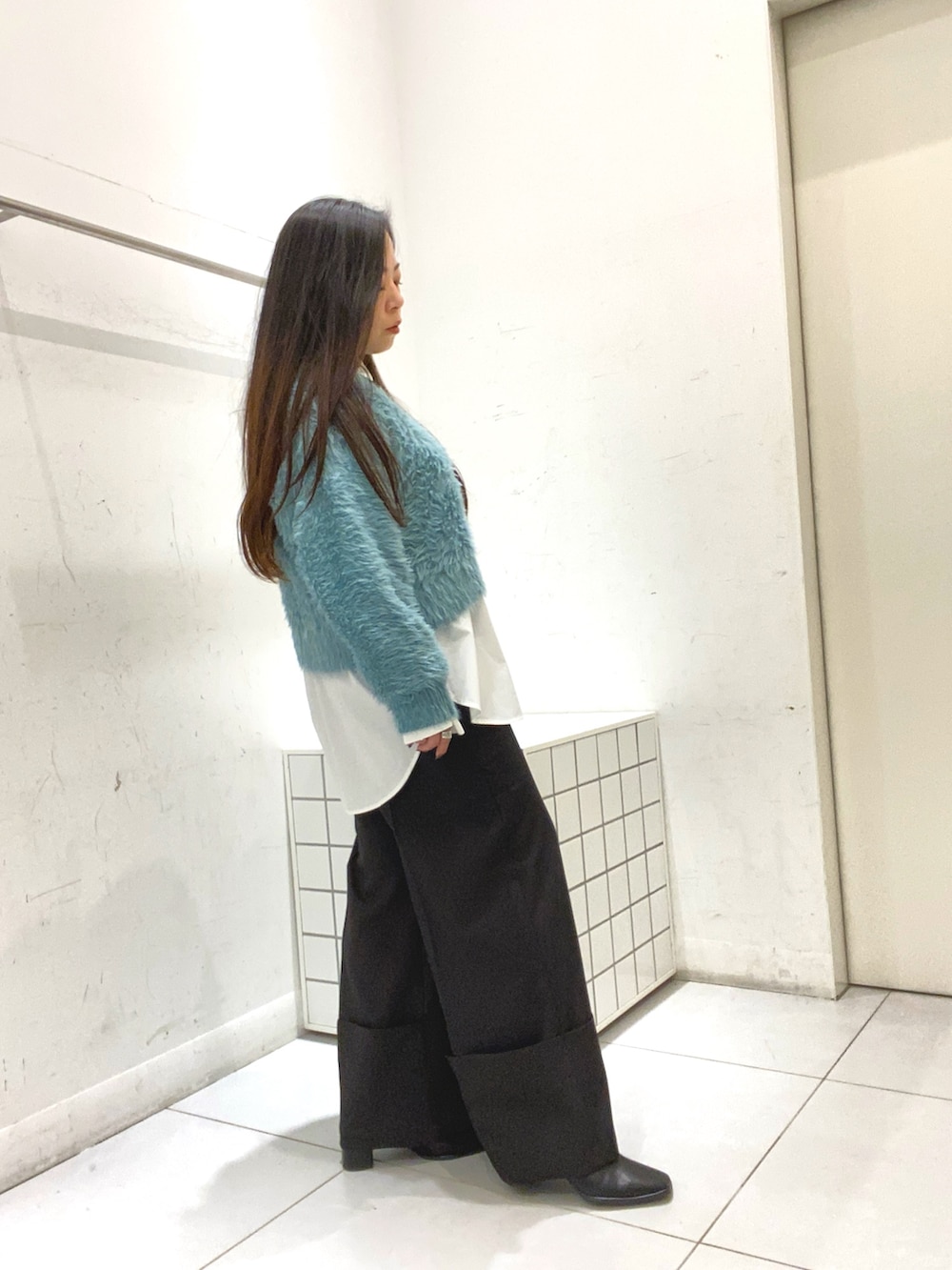 ブルー系のニット/セーター、ホワイト系のシャツ/ブラウス、ブラック系のその他パンツを着用したレディースの秋コーディネートの2枚目の写真