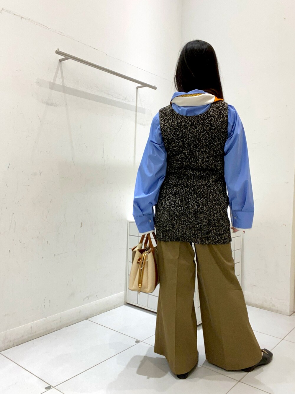 ベージュ系のその他パンツ、ホワイト系のハンドバッグ、ブラック系のベストを着用したレディースの冬コーディネートの3枚目の写真